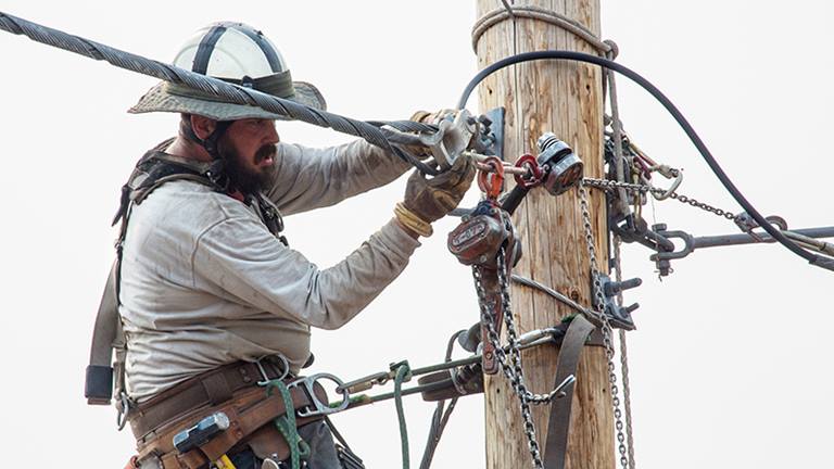 image of man working on power pole