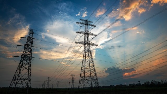 transmission lines set against a dark, stormy sky